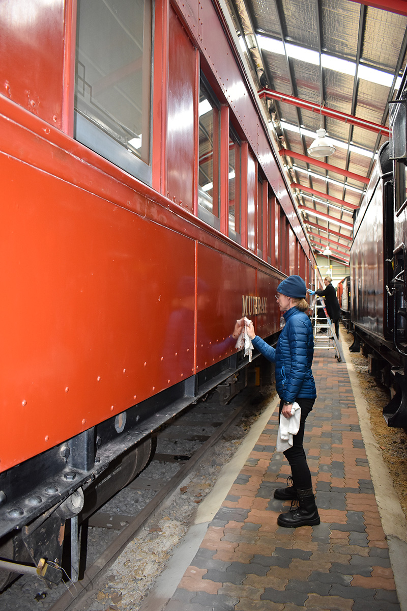 Conservator cleaning railway carriage